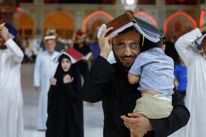 Fieles chiítas, con copias del Corán en sus cabezas, participan en una de las liturgias del mes sagrado del Ramadán en el Santuario Imam Ali, en la ciudad sagrada de Najaf, Irak.