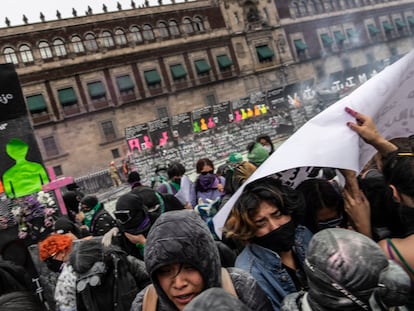 Manifestantes buscan refugio tras recibir gases lacrimógenos a las afueras de Palacio Nacional este 8-M en Ciudad de México.