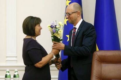 Yatseniuk (R) da un ramo de flores a su ministra de Finanzas.