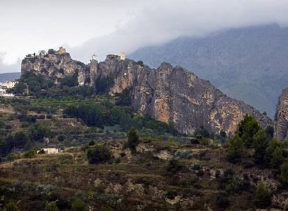 Vista de Guadalest, con la sierra de Serrella, al fondo, cubierta por las nubes.