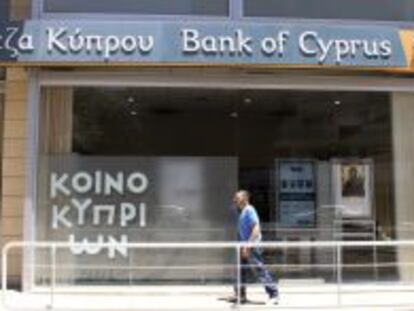 Un hombre pasa delante de una oficina del Banco de Chipre