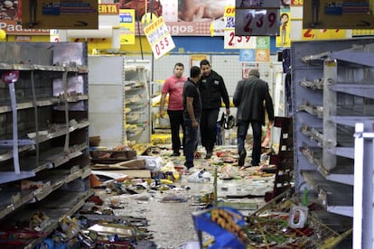 Guardas de seguridad en una tienda saqueada en Recife. Los bandidos aprovecharon la huelga de los policías militares para actuar.