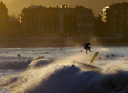 Numerosos surfistas disfrutan del atardecer hoy en la playa de La Zurriola de San Sebastián, donde tras varias semanas de frío y lluvia se han alcanzado los 15 grados en esta jornada.