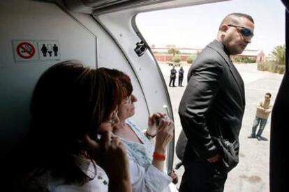 Un policía marroquí vigila que la alcaldesa Montserrat Muñoz (primera por la izquierda) no desembarque del avión.