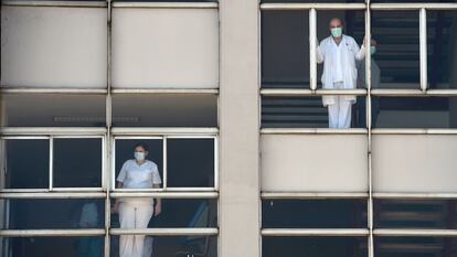 Médicos miran a través de las ventanas del Hospital Universitario de A Coruña.