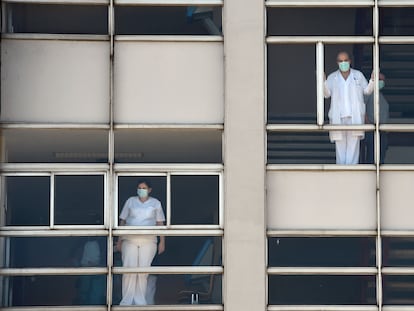 Médicos miran a través de las ventanas del Hospital Universitario de A Coruña.