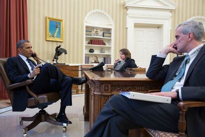 En esta foto enviada por la Casa Blanca, el presidente Obama habla por teléfono en el Despacho Oval con el director del FBI Robert Mueller, sentados frente al presidente están Lisa Monaco y Denis McDonough.