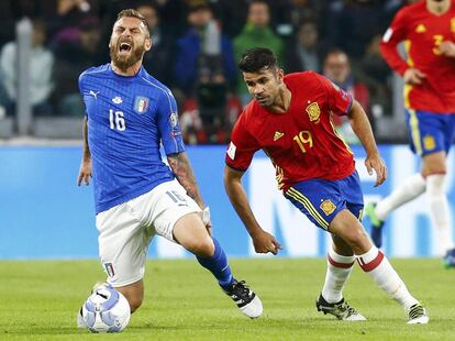 Daniele De Rossi de Italia se toca la pierna durante una jugada con Diego Costa de España.