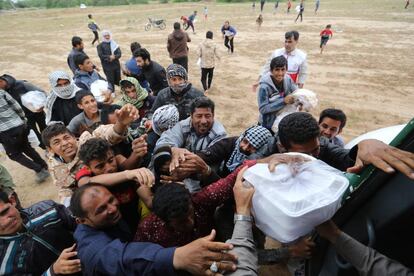 Varios iraníes se congregan junto a un helicóptero de la Media Luna Roja  para recoger alimentos, en la aldea de Susangerd en la provincia de Khuzestan (Irán). Las autoridades iraníes evacuaron a pacientes de un hospital amenazado por las inundaciones en la ciudad sudoeste de Ahvaz.