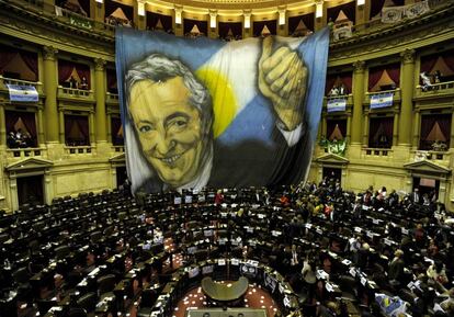 Los seguidores del fallecido Nestor Kichner desplegan una gran bandera con su cara en el Parlamento argentino, tras la votación de la ley.