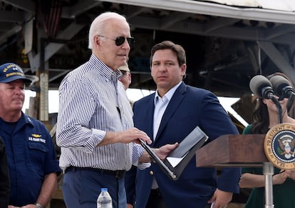 US President Joe Biden arrives to speak in a neighborhood impacted by Hurricane Ian on October 5, 2022, as Florida Governor Ron DeSantis looks on. 