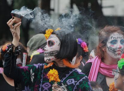 Pessoas participam durante o desfile de Catrinas por uma das principais avenidas da Cidade de México. Centenas de pessoas que participaram do evento foram maquiadas de caveira usando elementos mexicanos.