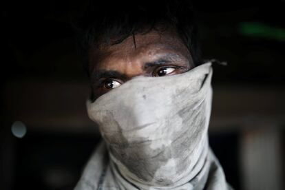 Un hombre usa una máscara mientras trabaja en un un astillero en Dhaka (Bangladesh).