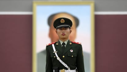 Un agente, en frente del retrato de Mao Zedong, en la plaza de Tiananmen (Pekín), el 23 de octubre