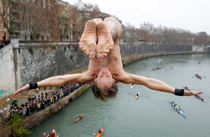 El italiano Marco Fois salta desde el puente Cavour al Tiber, siguiendo la tradición instaurada desde 1946 de pegarse un primer chapuzón saltando desde este puente romano.