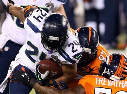 Marshawn Lynch, de Seattle, placado por la defensa de Denver