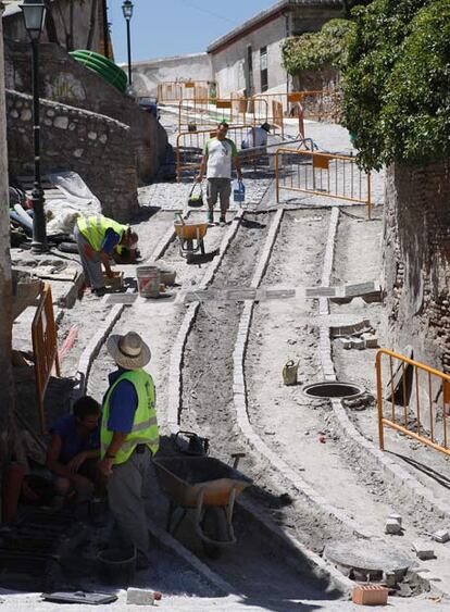Obras de cambio de empedrado en la Cuesta de la Lona del barrio del Albaicín, en Granada.