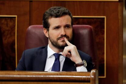 El presidente del PP, Pablo Casado, escucha el discurso del candidato a la Presidencia del Gobierno, Pedro Sánchez.