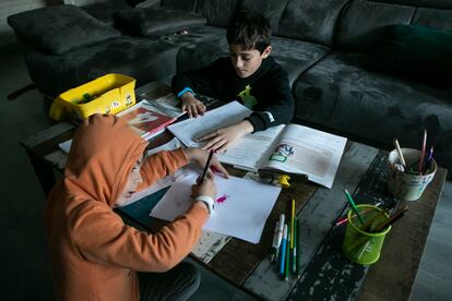 Dos niños estudiando en una casa de Madrid.