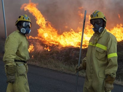 Dos personas durante las labores contra el incendio forestal declarado en Avi&oacute;n (Ourense).