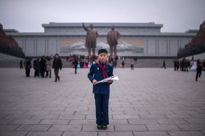 Kim Su-Min, de 11 anos, antes de colocar flores nas estátuas dos últimos líderes norte-coreanos Kim Il-Sung (esquerda) e Kim Jong-Il na colina Mansudae, em Pyongyang. Kim Su-Min presenciava o aniversário do nascimento do antigo líder do país Kim Jong-il, uma data festiva conhecida como “Dia da Estrela Brilhante”.