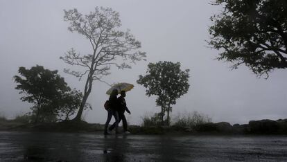 Unos jóvenes se protegen de la lluvia este sábado en Tegucigalpa (Honduras).