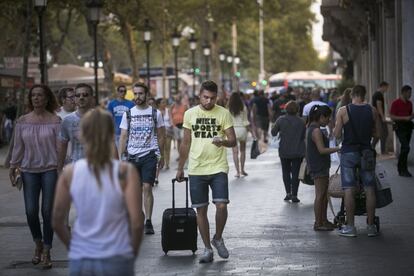 Un vianant amb una maleta i un 'smartphone'.