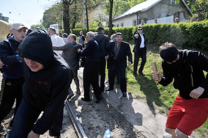 Un hombre saca su pistola durante un enfrentamiento entre grupos nacionalistas y prorusos, en la localidad de Lviv, Ucrania. Los prorusos se dirigían a un memorial para celebrar la victoria soviética sobre los nazis, cuando fueron increpados por los nacionalistas y comenzó una pelea monumental que se prolongó hasta la llegada de la policía.