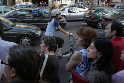 Una ciclista circula en la jornada de huelga ante una parada de autobús.