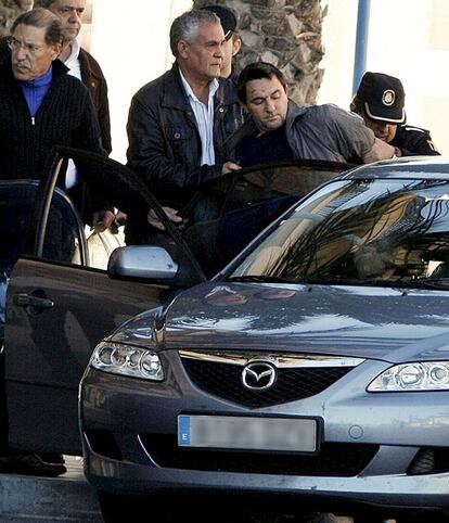 La policía introduce en un coche al hombre que atracó ayer un banco en Alicante.