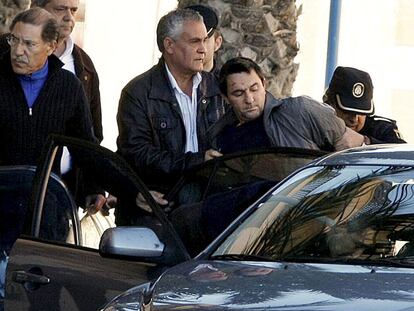 La policía introduce en un coche al hombre que atracó ayer un banco en Alicante.