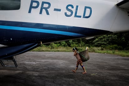 Un niño indígena carga una canasta al cruzar una pista aérea oficial. La Amazonia está plagada de pistas de aterrizaje ilegales para operaciones mineras. Oficiales del Ibama han advertido que el Ejército dejó de llevar combustible a las bases aéreas en territorio yanomami, limitando su operación; que la Fuerza Aérea no estableció una zona de restringida para el vuelo, a pesar de las órdenes del presidente Lula; y que la Marina no ha hecho suficiente para evitar que los 'garimpeiros' transporten maquinaria y provisiones por los ríos.