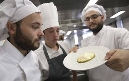 Cocineros sirven un huevo frito sobre los poros del plato 'Hola'.