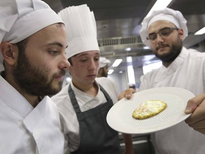 Cocineros sirven un huevo frito sobre los poros del plato 'Hola'.