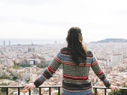 Una mujer observa Barcelona desde el Turó de la Rovira.
 