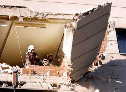 Bomberos de la Generalitat de Cataluña retiran escombros del edificio de Cornellá donde se ha registrado la explosión.