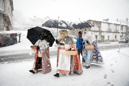 Los Reyes Magos se refugian de la nieve a su llegada a Pedrafita do Cebreiro, este viernes en Lugo.