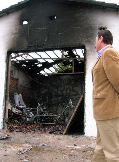 Lope Benavente de Blas, alcalde de Villaconejos (Madrid), ante la casa quemada.
