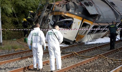 Agentes de la Guardia Civil junto al tren descarrilado esta ma&ntilde;ana en las inmediaciones de la estaci&oacute;n de tren de O Porri&ntilde;o (Pontevedra).