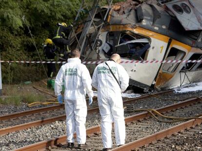 Agentes de la Guardia Civil junto al tren descarrilado esta ma&ntilde;ana en las inmediaciones de la estaci&oacute;n de tren de O Porri&ntilde;o (Pontevedra).