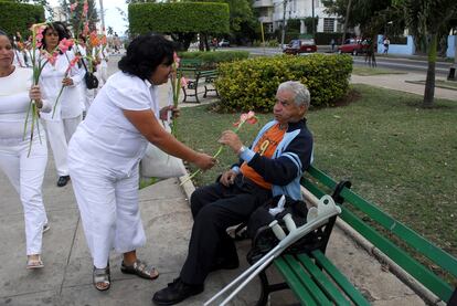 Una integrante del grupo de mujeres Damas de Blanco entrega una flor a un hombre hoy martes 16 de marzo de 2010 durante una marcha en la Avenida de los Presidentes de La Habana.