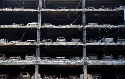 Restos de automóviles quemados en el estacionamiento del 'Liverpool Echo Arena', destruido en un incendio hace casi un año, en Liverpool (Gran Bretaña). Las autoridades están comenzando con su demolición.
