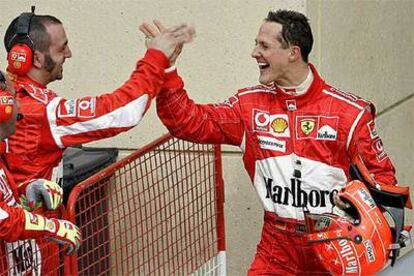 Schumacher es felicitado por miembros de Ferrari tras la clasificación.