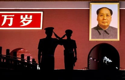 Saludo entre dos policías que hacen guardia junto a un retrato de Mao Zedong en la plaza de Tiananmen el 4 de junio de 2014 en Pekín, China. 