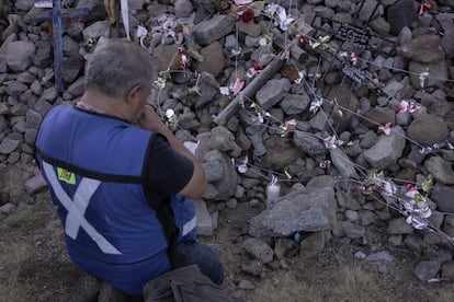 Un hombre que ha hecho el camino a Chalma durante 42 años prende una vela y reza junto al montículo de rocas y cruces.