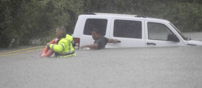 Un agent del xèrif rescata un home del seu cotxe a Houston, diumenge.