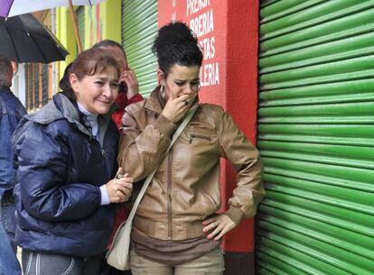 Local residents mourn outside the closed newspaper stand of Miguel Ángel Domingo on Thursday.