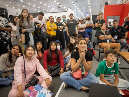 Asistentes a la FIL observan el partido México vs Argentina en los pasillos de la Feria Internacional del Libro de Guadalajara.