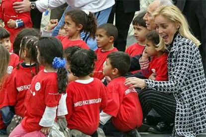 Sharon Stone y Simón Peres, sentados con niños israelíes y palestinos en un estadio cerca de Tel Aviv.