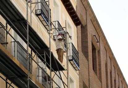 Un hombre trabaja en la rehabilitaci&oacute;n de una fachada en Madrid